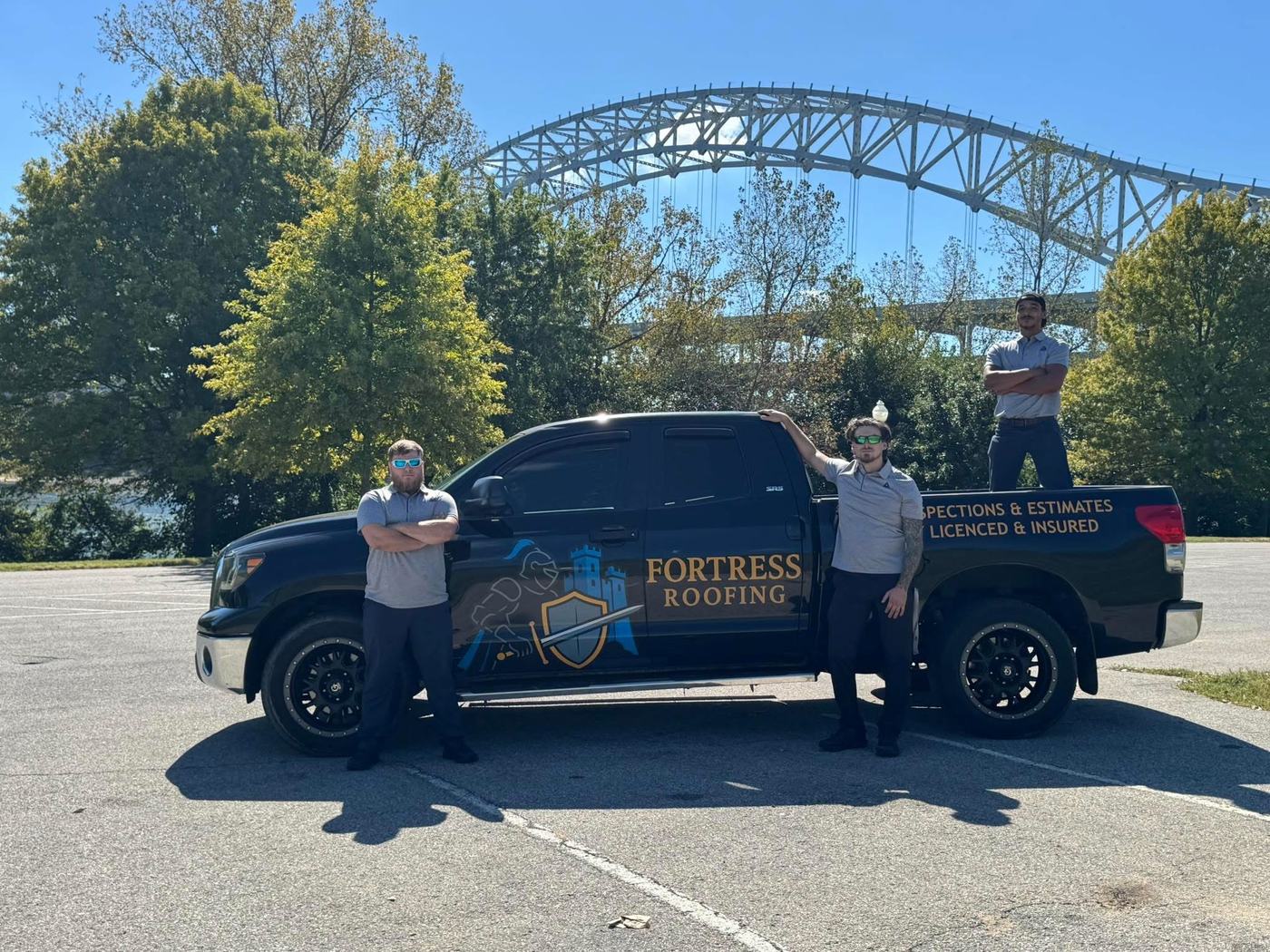 Fortress Roofing LLC team standing with the branded work truck